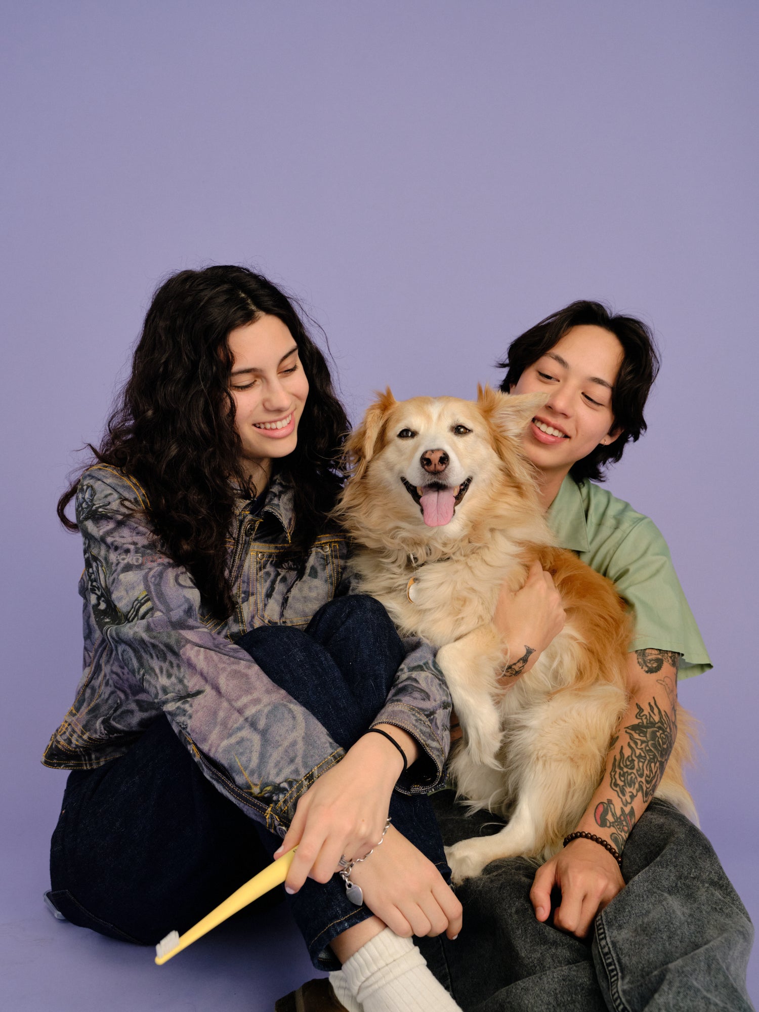 A couple holding an Oreze brush and their happy dog.
